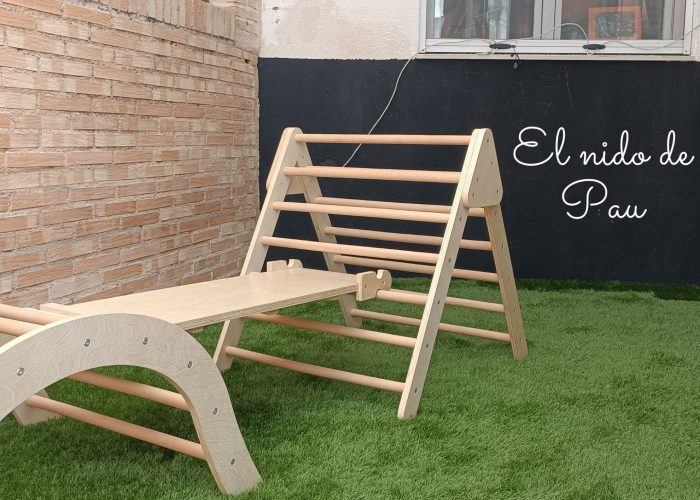 Patio Zona exterior con pizarra y materiales Pikler (triángulo Pikler, arco Pikler y rampa Pikler).